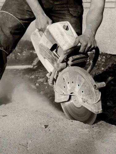 Close-up of man cutting concrete with a circular saw